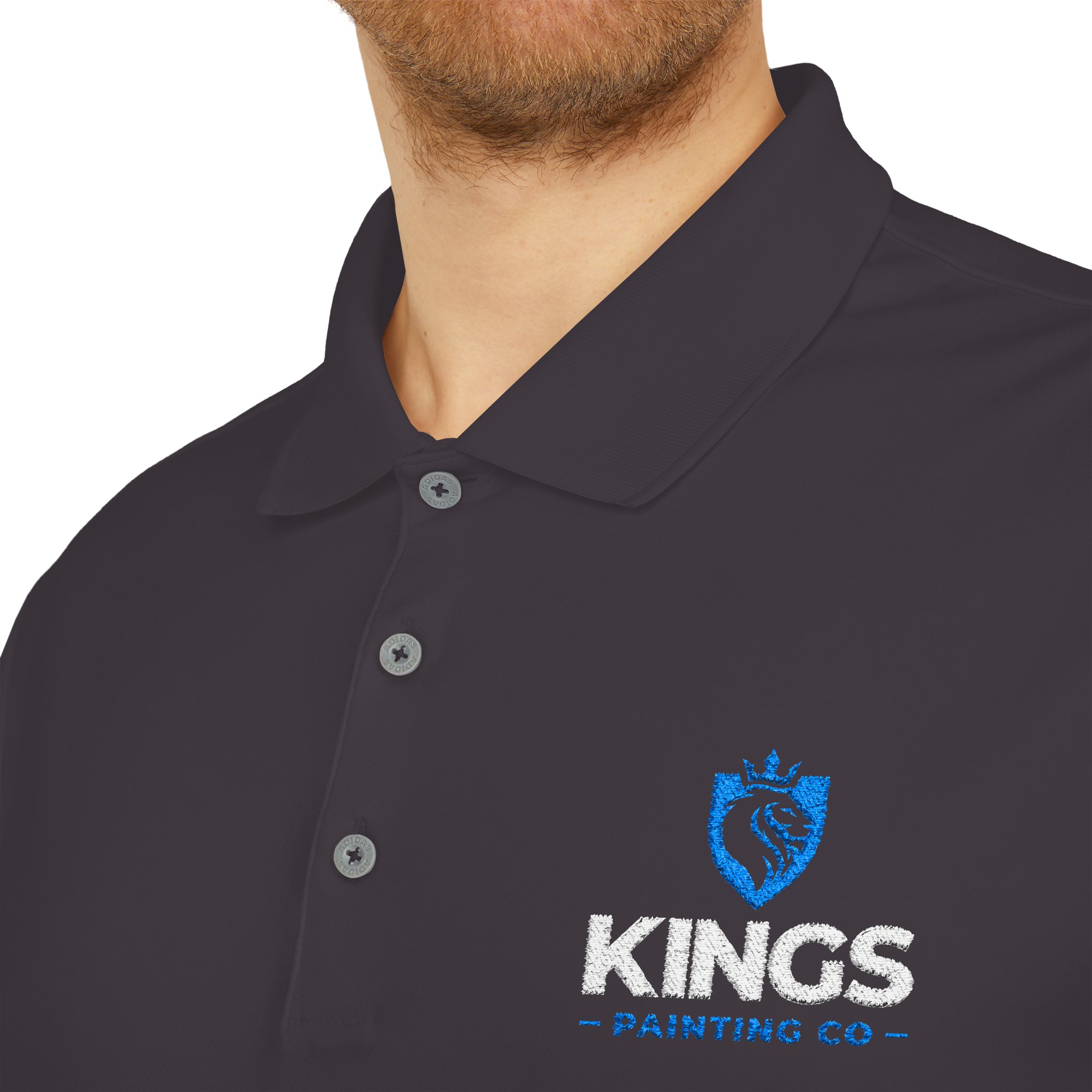 A man is shown wearing the Kings Painting Co. Performance Polo by Under Armour®, featuring an embroidered blue lion logo and "KINGS PAINTING CO" text on the left chest. Only his lower face, neck, and upper torso are visible.